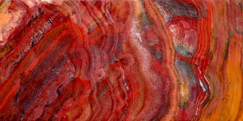 Fototapeta premium Onyx is a variety of agate. The texture of the surface of a beautiful stone. Brown, red, white, yellow color on a semi-precious mineral