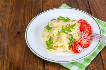 Spaghetti with cheese, tomatoes and arugula