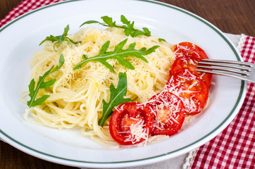 Spaghetti with cheese, tomatoes and arugula