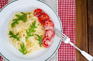 Spaghetti with cheese, tomatoes and arugula