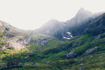 Mountain landscape at summer in Lofoten, Norway. Vibrant image of shadow and light illuminating mountainside.