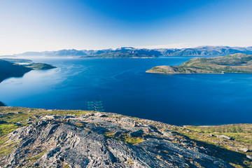 Salmon farms in Norwegian fjord,  near Alta. View from high mountain peak at sunny day. - 241165706