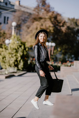 Fototapeta premium Young pretty woman walking up the stairs in the city outdoors