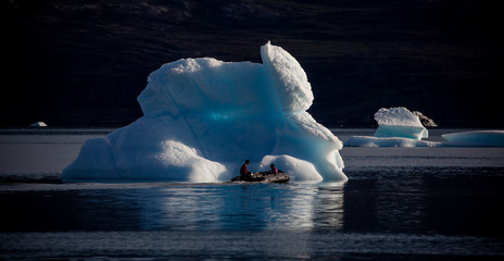zodiac driving through arctic landscape with high fjords and floating icebergs © Agata Kadar
