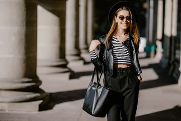 Fototapeta premium Fashion woman portrait. Young pretty trendy girl posing at the city in Europe.