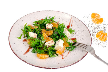 Delicious fruit and vegetables salad. Tangerine, feta cheese, arugula and chia seeds in plate. Healthy food concept