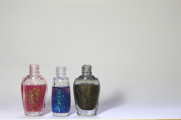Bottle of colorful glittering nail polish. Space in blank to insert text about nail polish, vanity, beauty, trends
