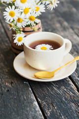 cup of herbal chamomile tea with fresh daisy flowers on wooden background. doctor treatment and prevention of immune concept, medicine - folk, alternative, complementary, traditional medicine 