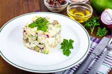 Dishes with avocado, salad with mushrooms and eggs, mayonnaise sauce