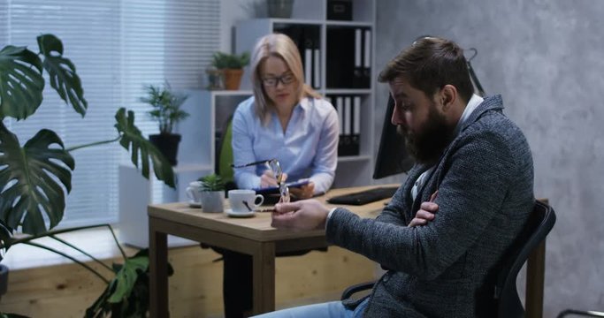 Medium shot of young man talking to a female psychologist