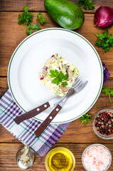 Dishes with avocado, salad with mushrooms and eggs, mayonnaise sauce
