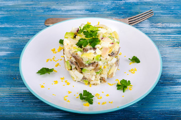 Tasty salad with squid and avocado on blue background