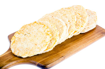 Frozen raw potato pancakes on cutting board for cooking