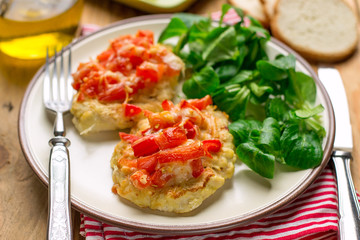 Oven baked chicken breasts topped with tomatoes and bell peppers