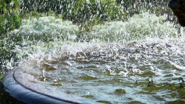 fountain. drops of water fall down. artificial water source. water pipes. a park. heavy rain. super slow motion