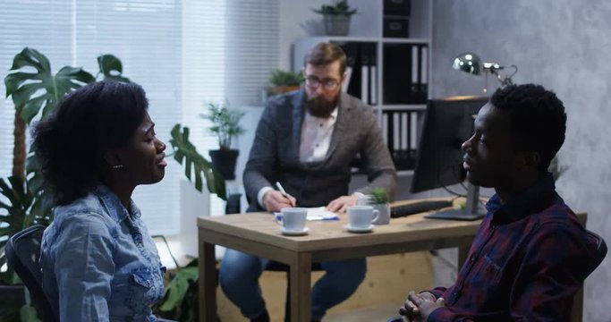 Medium shot of young couple arguing in the office of a psychologist