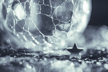 Macro photo of cracked glass sphere silver star with light bokeh
