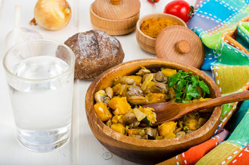 Wooden bowl with vegetable stew with mushrooms