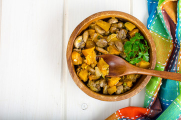 Wooden bowl with vegetable stew with mushrooms