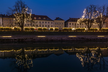 Christmas decorated houses reflecting in the Ljubljanica river