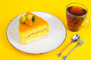 Piece of mousse cake on bright yellow background