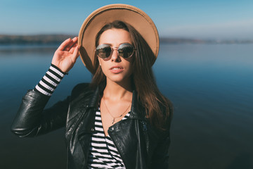 Portrait of young beauty woman in sunglasses and straw hat on lake water background