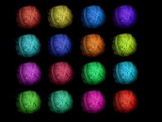 Multi-colored skeins of wool on a black background. Multicolored balls. Colored wool in the balls.