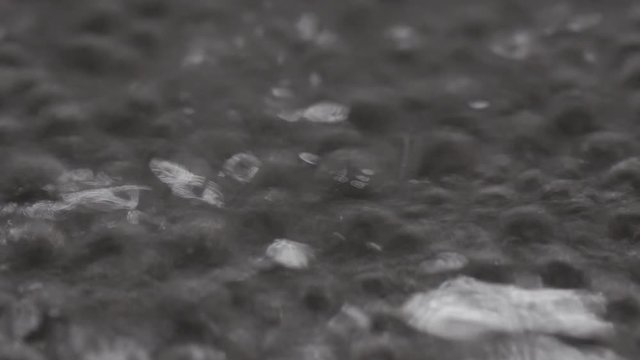 Bubbles of water boiling in a black pan. Close up