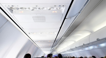 Interior view of the seats and ceiling of a commercial airplane.