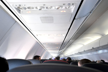 Interior view of the seats and ceiling of a commercial airplane.