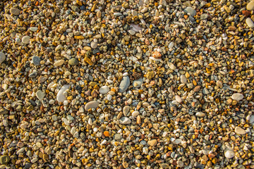 colorful sea stones shoreline background texture material surface foreshortening from above wallpaper pattern concept