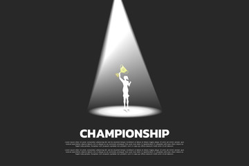Silhouette of businesswoman with golden trophy in spotlight. business concept of winner and champion