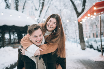 beautiful young couple having fun on a snowy street