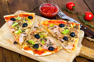 Sliced pizza with mozzarella cheese, ham, mushrooms, olives