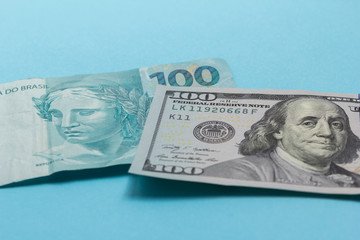 Brazilian Reais and North American currency. Dollar. Bills on colorful bright table