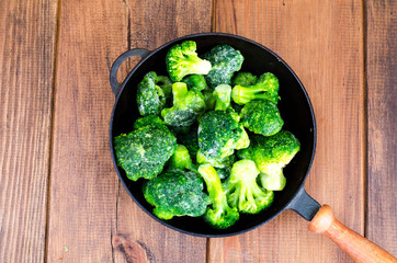 Cast iron pan with frozen broccoli for cooking
