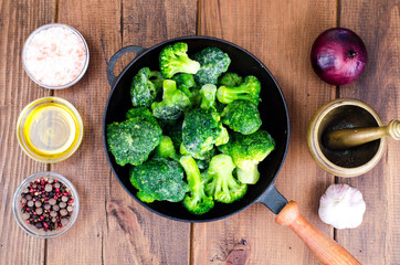 Cast iron pan with frozen broccoli for cooking