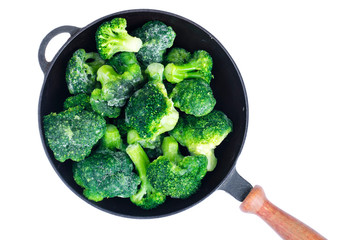 Cast iron pan with frozen broccoli for cooking