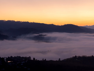 Mountain and foggy at morning time with orange sky, beautiful landscape in the thailand