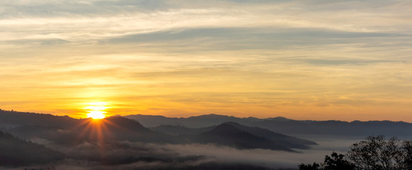 Mountain and foggy at morning time with orange sky, beautiful landscape in the thailand