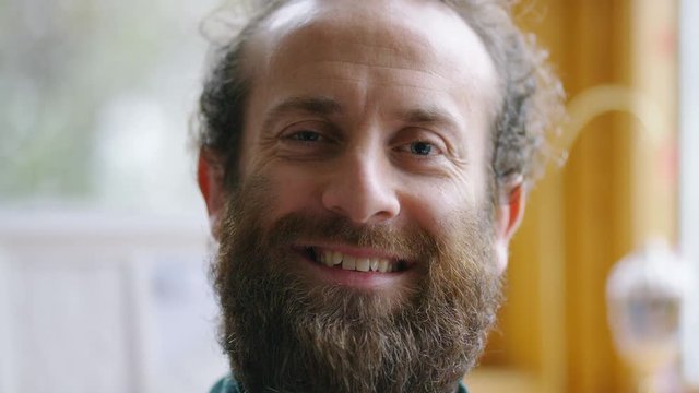 Portrait of happy and comfortable middle aged man with a beard smiling to camera