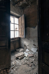 Fototapeta na wymiar Illuminated window of a house about to collapse