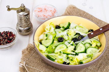 Healthy food. Vegetarian salad from iceberg, fresh cucumber and black olives
