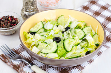 Healthy food. Vegetarian salad from iceberg, fresh cucumber and black olives