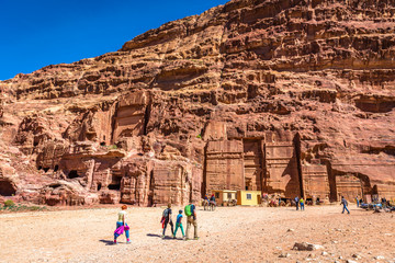 Petra, Jordan - Feb 15th 2018 - A family walking in front of a mountain with carving temples in Petra in Jordan