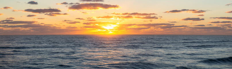 Panoramic view of the ocean during a vibrant cloudy sunrise. Taken in Daytona Beach, Florida, United States.