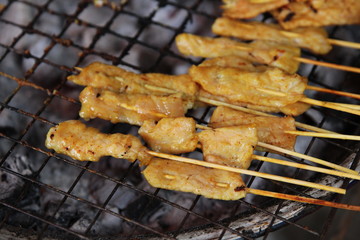 Thai street food. Grilled spices pork on Charcoal stove (Pork Satay) in Baan Ton Tan Floating Market, Sao Hai, Saraburi, Thailand