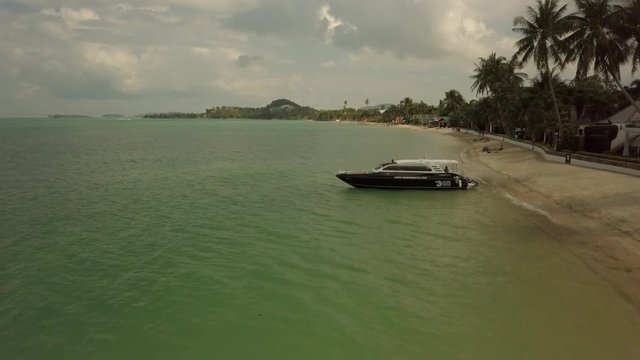 Adobe Stock DRONE 4k passing over boat at beach kom samui
