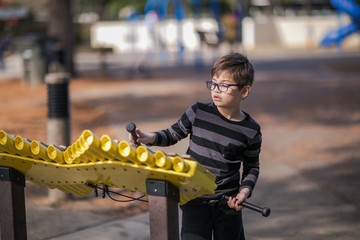 Boy Playing Musical Instrument xylophone Outside at the Park
