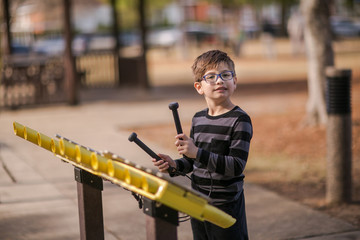 Boy Playing Musical Instrument xylophone Outside at the Park